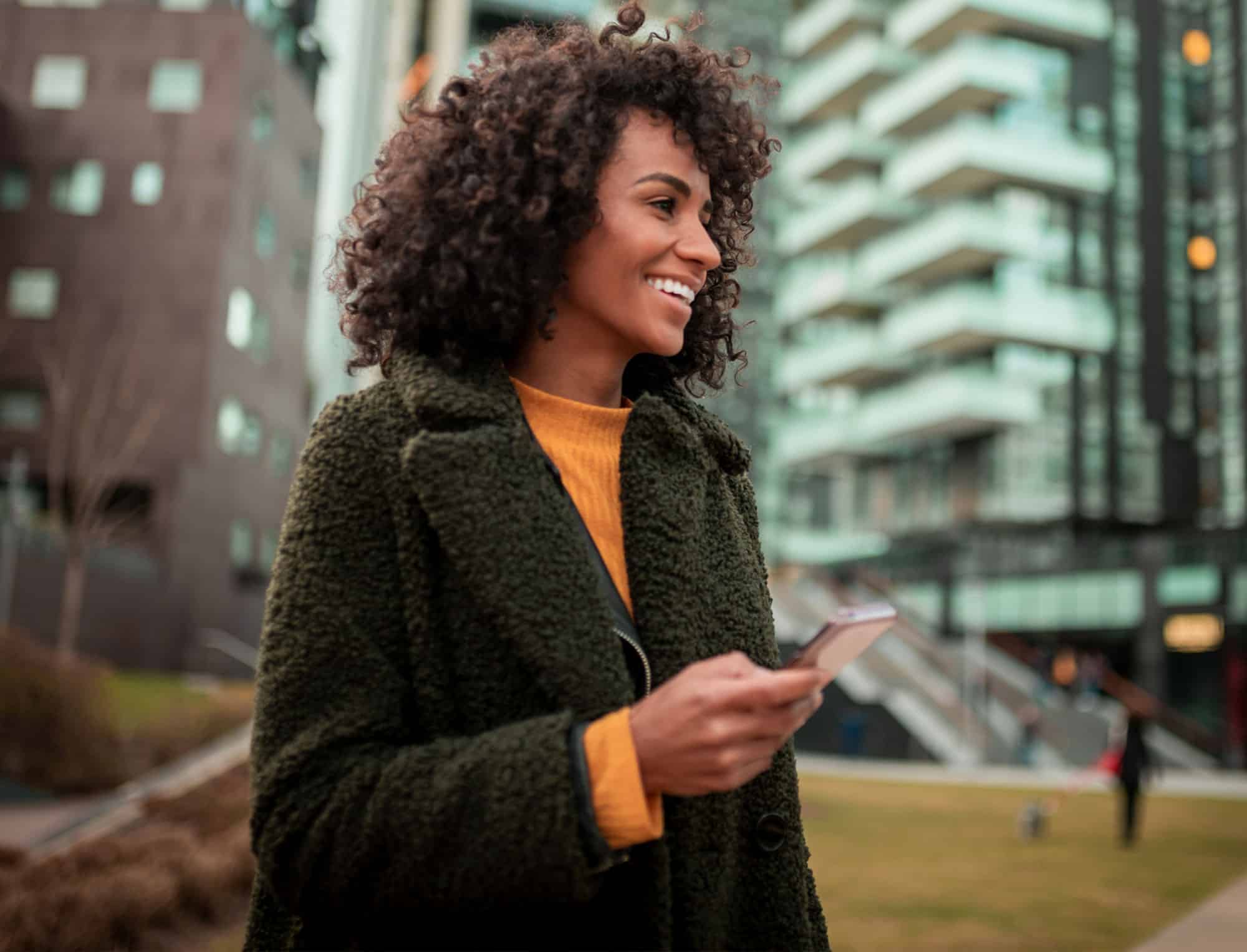 a woman standing in front of a building talking on a cell phone