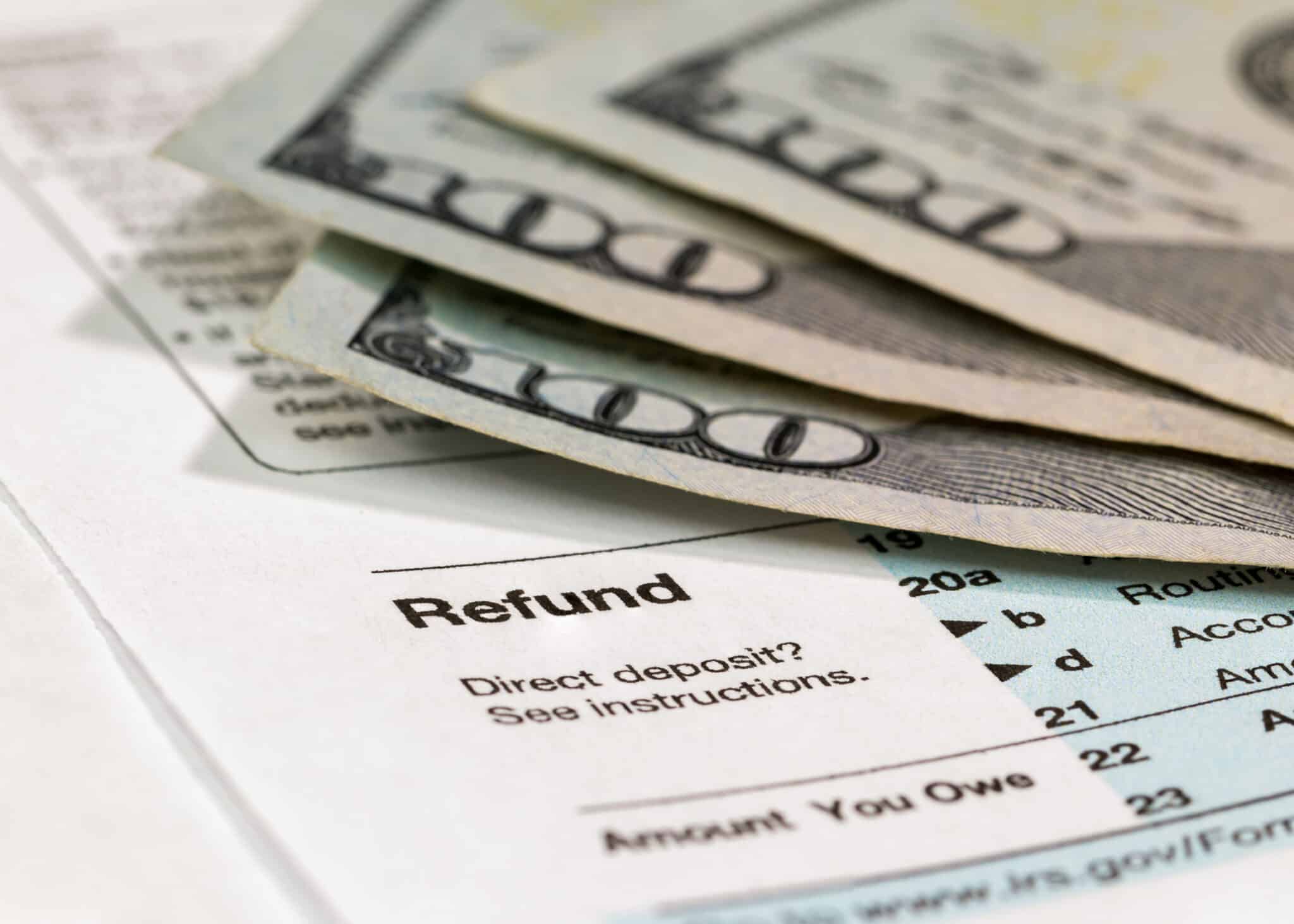 Tax return form with money in background representing smart tax season banking and saving your refund with linked accounts.